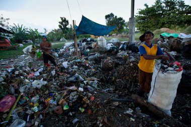 BALI, INDONESIA  APRIL 11: Poor from Java island working in a scavenging at the dump on April 11, 2012 on Bali, Indonesia. Bali daily produced 10,000 cubic meters of waste.